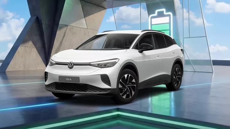 VW ID.4 steht in einem Raum, Lichtleisten im Hintergrund und großes grünes Batteriesymbol