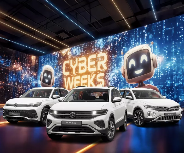 Drei VW-Modelle vor einer großen digitalen Wand mit leuchtendem Schriftzug "CYBER WEEKS" und zwei lächelnden Roboter.