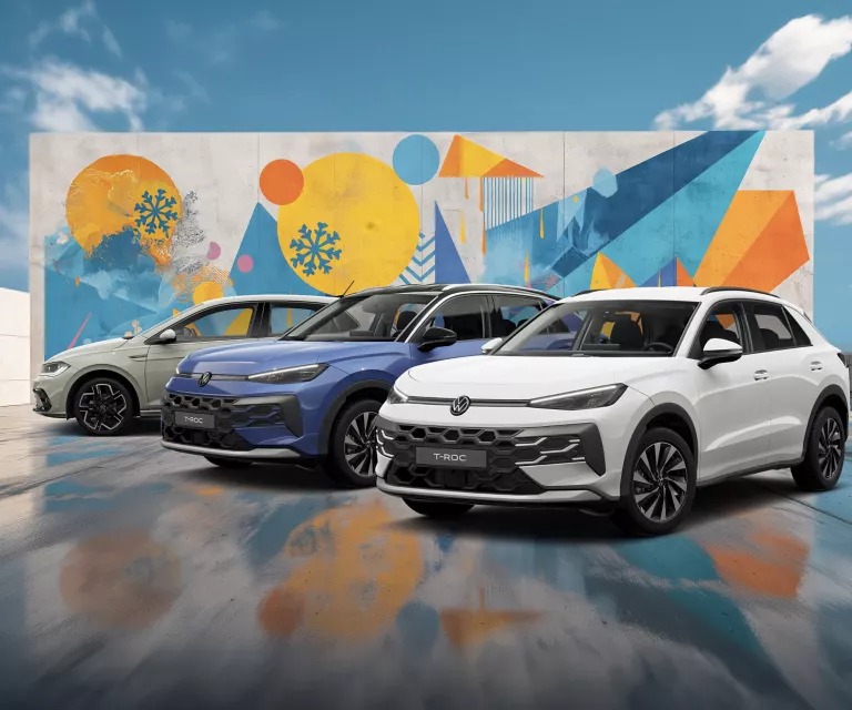 Drei VW-Modelle vor einer Wand mit winterlich, farbenfrohem, geometrischem Street-Art-Graffiti.