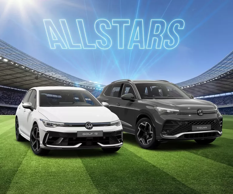 Zwei VW Modelle stehen auf einem Fußballfeld im Stadion, darüber leuchtet der Schriftzug „ALLSTARS“.
