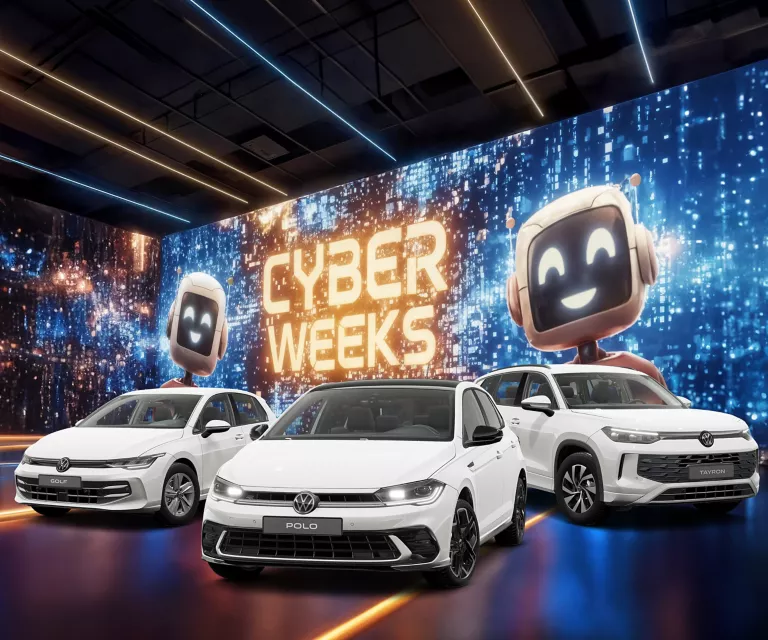 Drei VW-Modelle vor einer großen digitalen Wand mit leuchtendem Schriftzug "CYBER WEEKS" und zwei lächelnden Roboter.