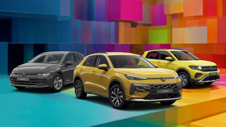 Drei VW-Modelle vor einem bunten, geometrischen Hintergrund aus leuchtenden 3D-Blöcken.
