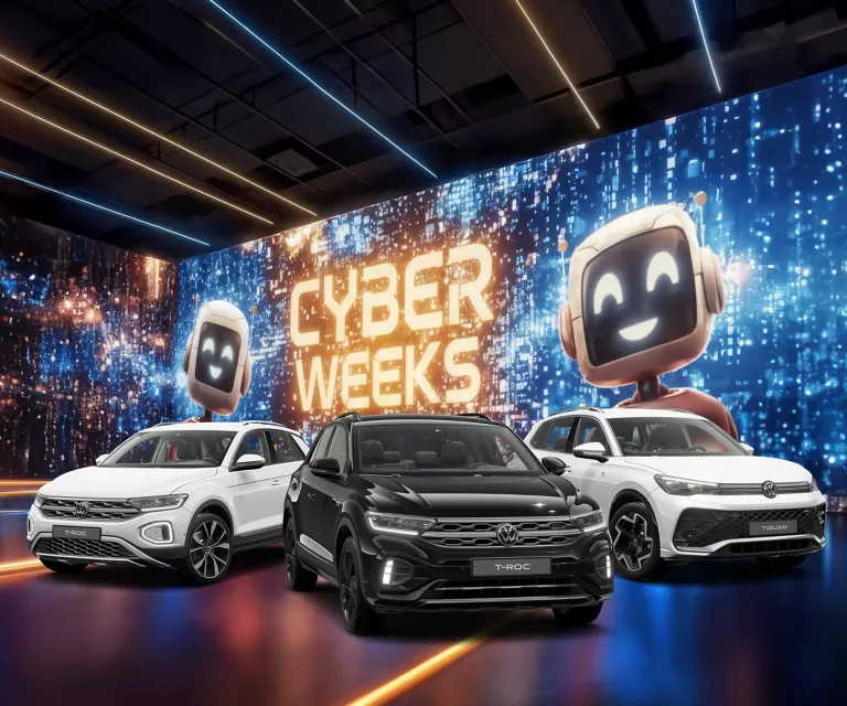 Drei VW-Modelle vor einer großen digitalen Wand mit leuchtendem Schriftzug "CYBER WEEKS" und zwei lächelnden Roboter.
