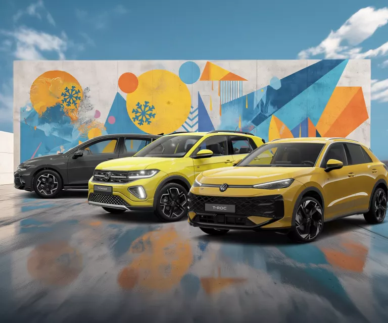 Drei VW-Modelle vor einer Wand mit winterlich, farbenfrohem, geometrischem Street-Art-Graffiti.