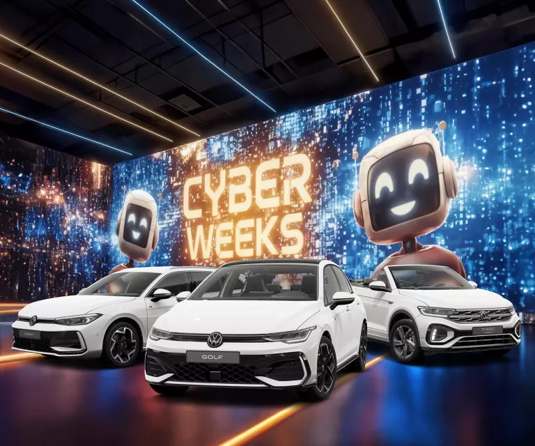 Drei VW-Modelle vor einer großen digitalen Wand mit leuchtendem Schriftzug "CYBER WEEKS" und zwei lächelnden Roboter.