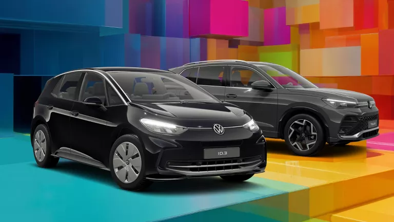 Zwei VW-Modelle vor einem bunten, geometrischen Hintergrund aus leuchtenden 3D-Blöcken.