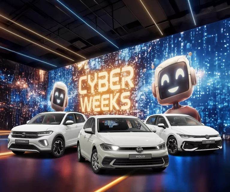 Drei VW-Modelle vor einer großen digitalen Wand mit leuchtendem Schriftzug "CYBER WEEKS" und zwei lächelnden Roboter.