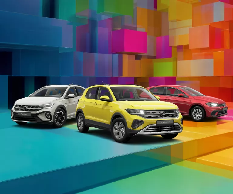 Drei VW-Modelle vor einem bunten, geometrischen Hintergrund aus leuchtenden 3D-Blöcken.