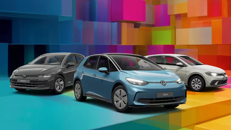 Drei VW-Modelle vor einem bunten, geometrischen Hintergrund aus leuchtenden 3D-Blöcken.