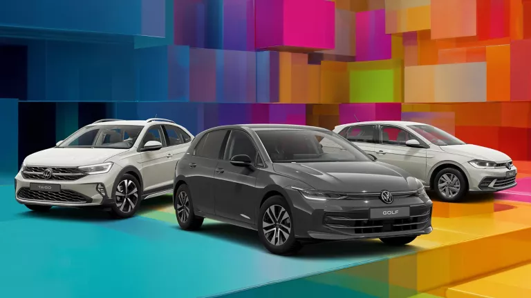 Drei VW-Modelle vor einem bunten, geometrischen Hintergrund aus leuchtenden 3D-Blöcken.