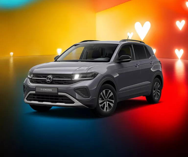 T-Cross in Grau vor gelb-rotem Hintergrund mit weißen Herzsymbolen.