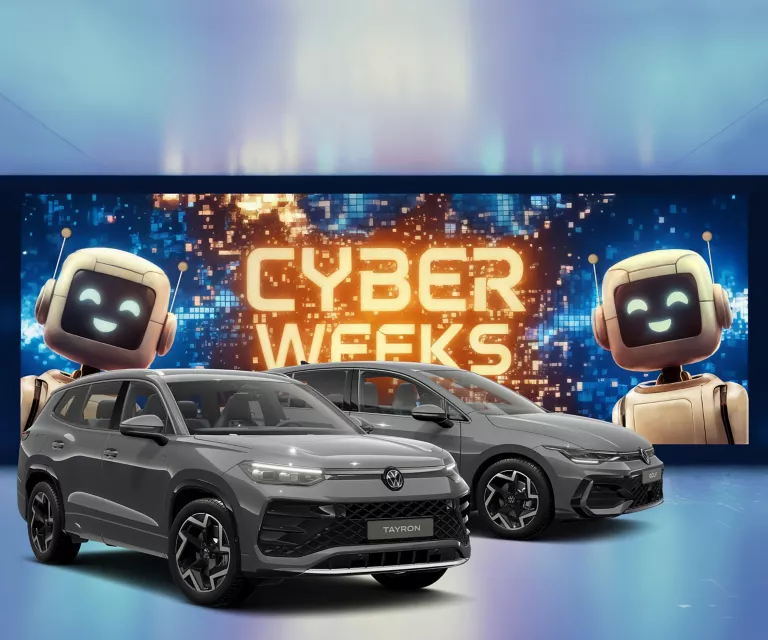 Zwei VW Modelle in Grau vor digitaler Wand mit leuchtendem Schriftzug "CYBER WEEKS" und zwei lächelnden Roboterfiguren.  