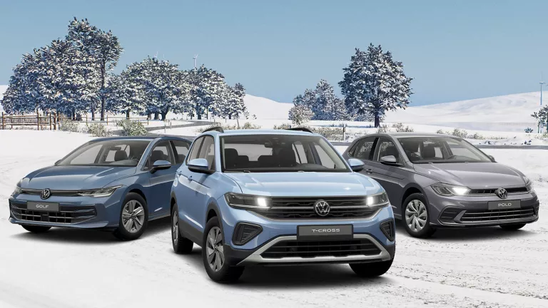 Drei VW Modelle in Blau und Grau stehen nebeneinander auf einer verschneiten Landschaft.