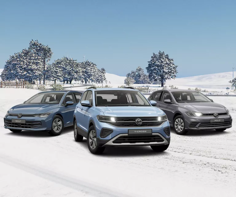 Drei VW Modelle in Blau und Grau stehen nebeneinander auf einer verschneiten Landschaft.