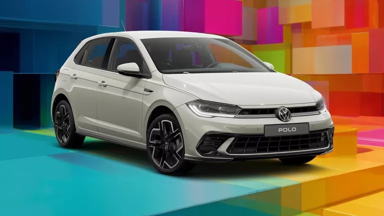 VW-Modell vor einem bunten, geometrischen Hintergrund aus leuchtenden 3D-Blöcken.