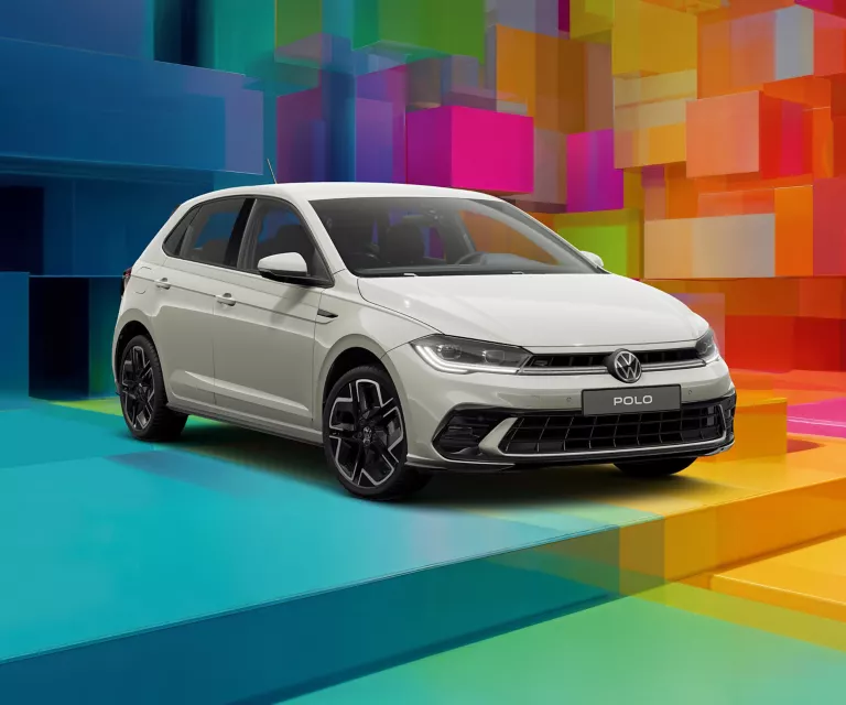 VW-Modell vor einem bunten, geometrischen Hintergrund aus leuchtenden 3D-Blöcken.