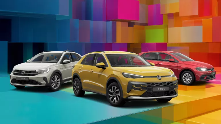 Drei VW-Modelle vor einem bunten, geometrischen Hintergrund aus leuchtenden 3D-Blöcken.