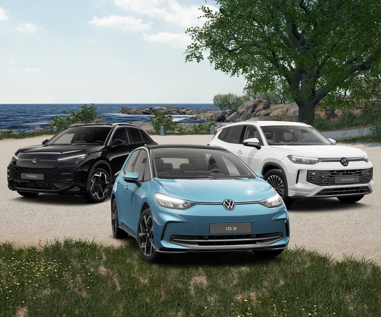 Drei VW-Modelle vor einem sommerlichen strand.