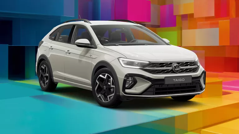 VW-Modell vor einem bunten, geometrischen Hintergrund aus leuchtenden 3D-Blöcken.