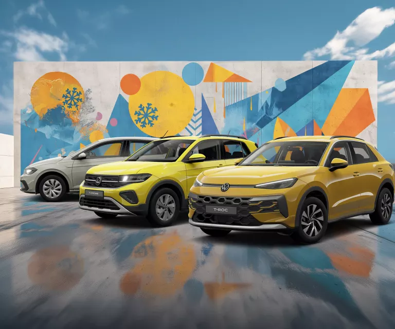 Drei VW-Modelle vor einer Wand mit winterlich, farbenfrohem, geometrischem Street-Art-Graffiti.