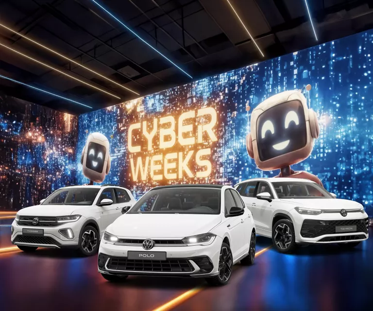 Drei VW-Modelle vor einer großen digitalen Wand mit leuchtendem Schriftzug "CYBER WEEKS" und zwei lächelnden Roboter.