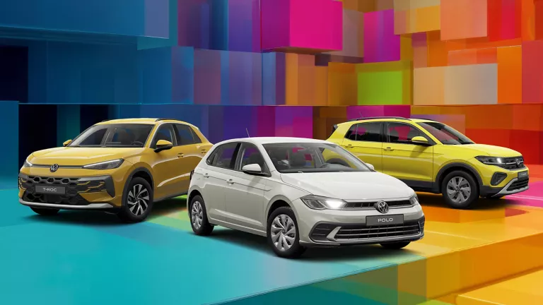Drei VW-Modelle vor einem bunten, geometrischen Hintergrund aus leuchtenden 3D-Blöcken.