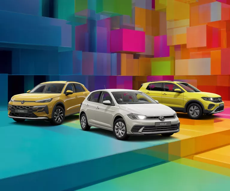 Drei VW-Modelle vor einem bunten, geometrischen Hintergrund aus leuchtenden 3D-Blöcken.
