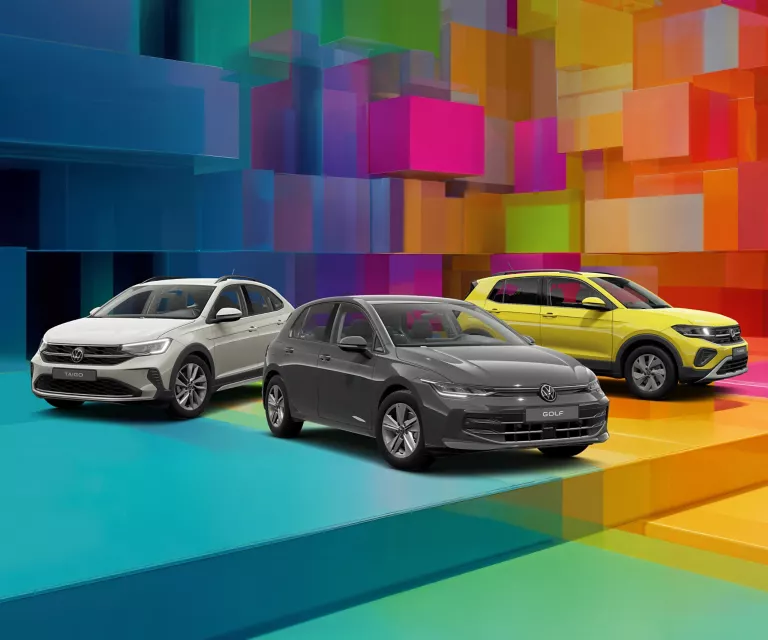Drei VW-Modelle vor einem bunten, geometrischen Hintergrund aus leuchtenden 3D-Blöcken.