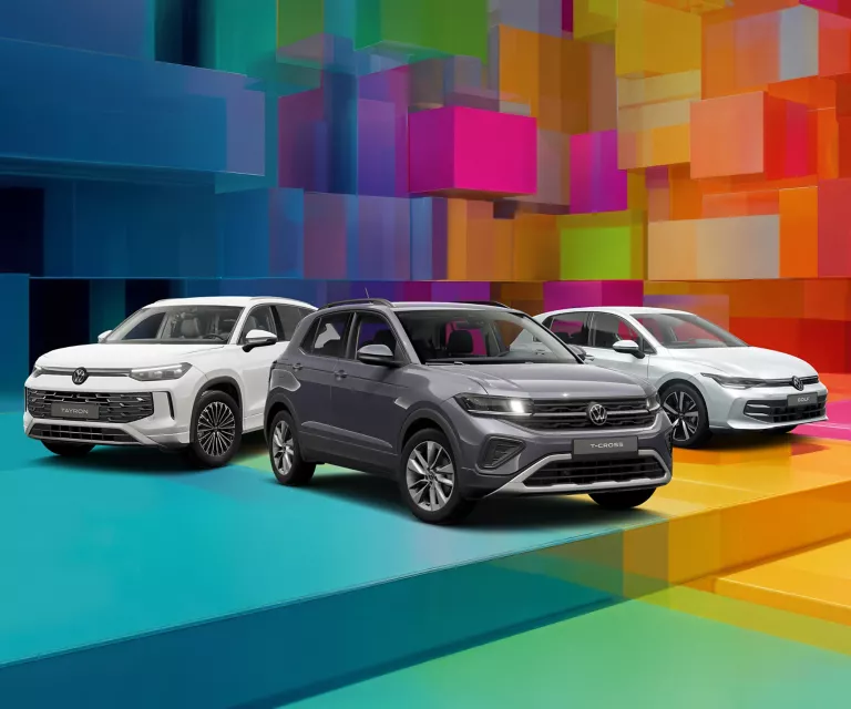 Drei VW-Modelle vor einem bunten, geometrischen Hintergrund aus leuchtenden 3D-Blöcken.