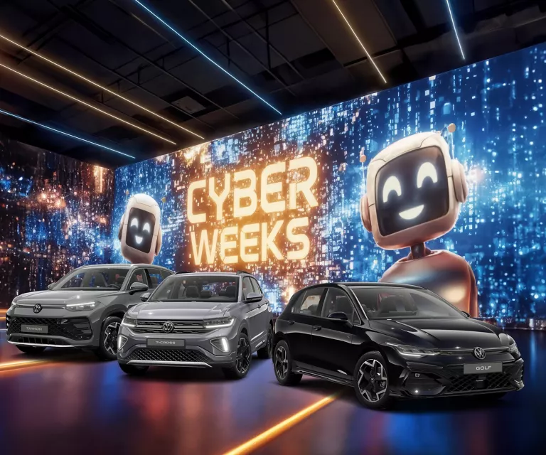 Drei VW-Modelle vor einer großen digitalen Wand mit leuchtendem Schriftzug "CYBER WEEKS" und zwei lächelnden Roboter.