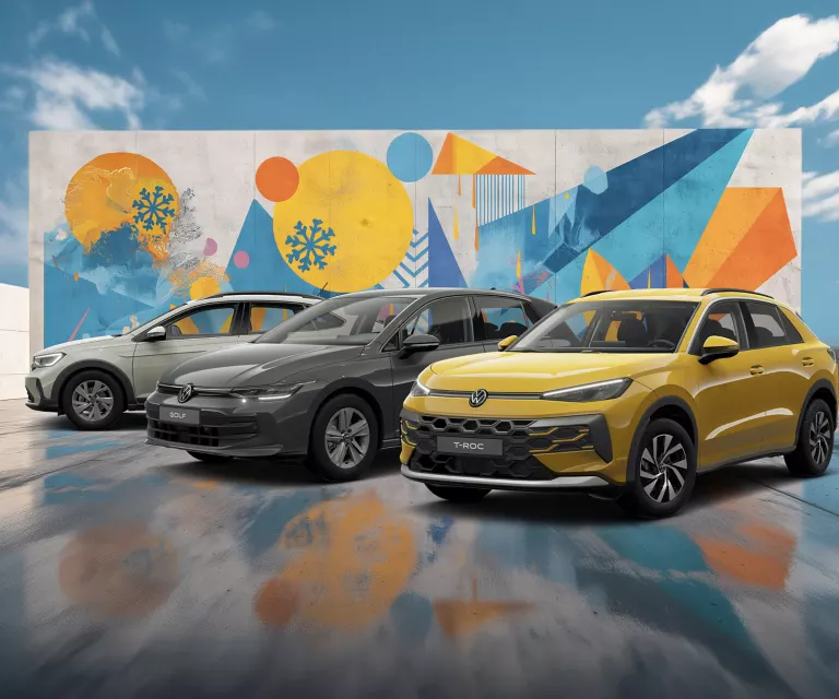 Drei VW-Modelle vor einer Wand mit winterlich, farbenfrohem, geometrischem Street-Art-Graffiti.