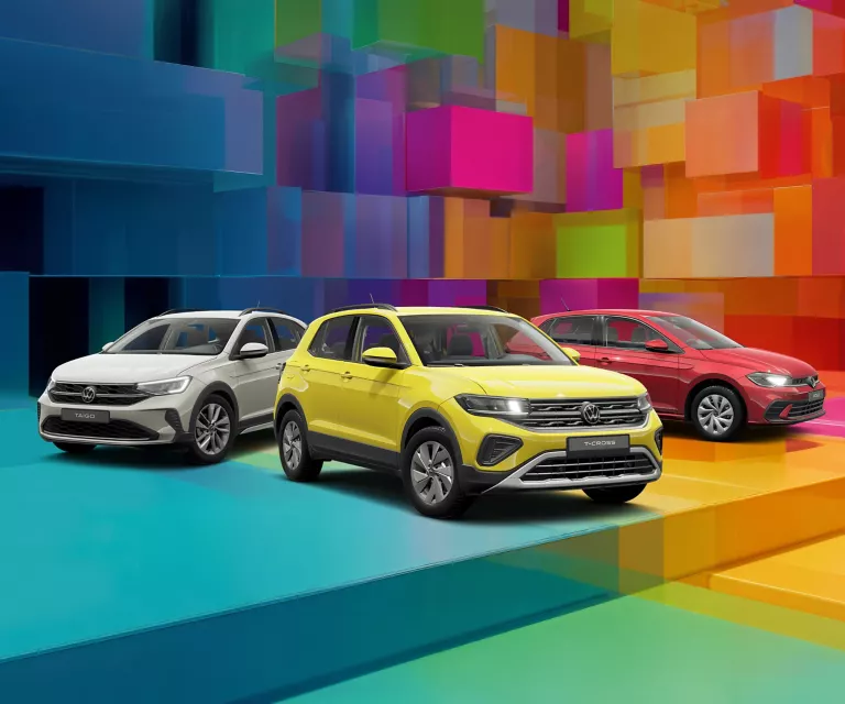 Drei VW-Modelle vor einem bunten, geometrischen Hintergrund aus leuchtenden 3D-Blöcken.