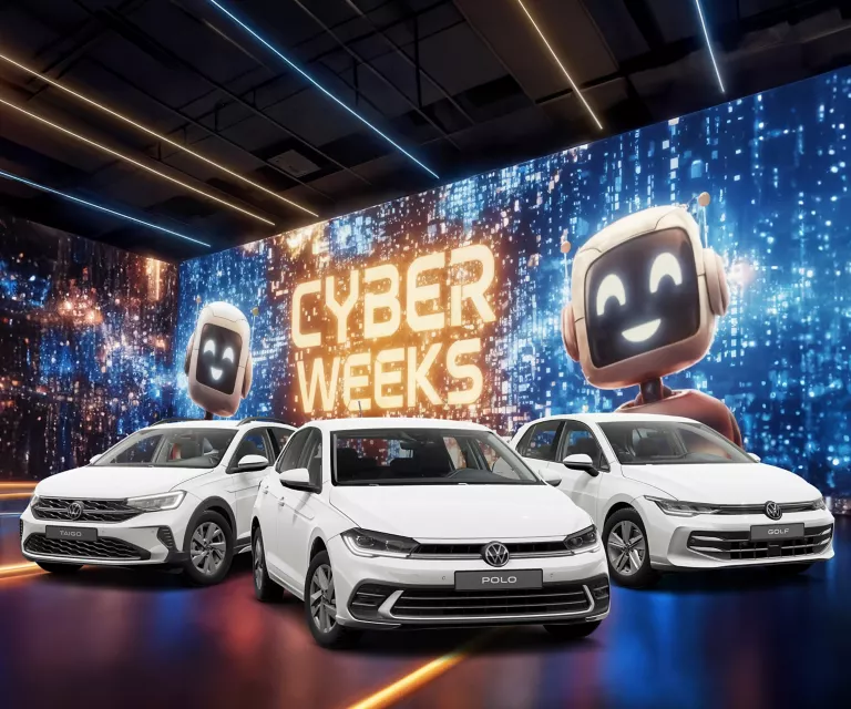 Drei VW-Modelle vor einer großen digitalen Wand mit leuchtendem Schriftzug "CYBER WEEKS" und zwei lächelnden Roboter.