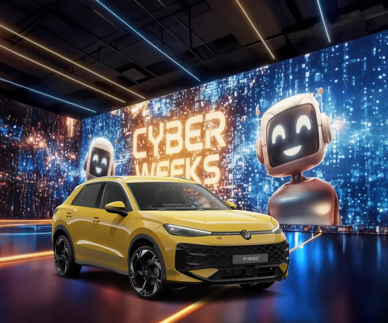 VW T-Roc in Gelb vor digitaler Wand mit leuchtendem Schriftzug "CYBER WEEKS" und zwei lächelnden Roboterfiguren.