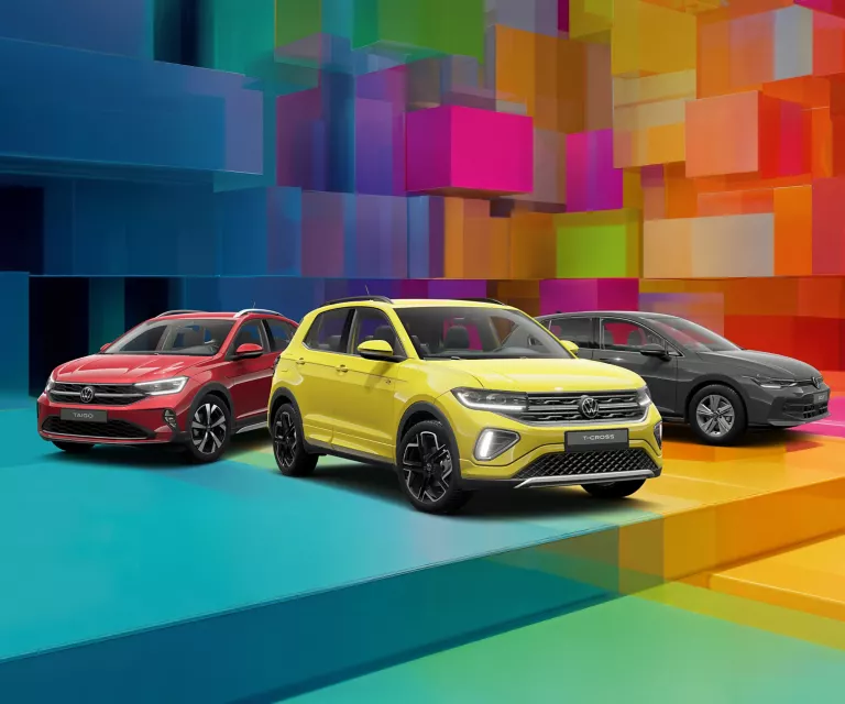 Drei VW-Modelle vor einem bunten, geometrischen Hintergrund aus leuchtenden 3D-Blöcken.