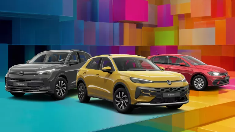 Drei VW-Modelle vor einem bunten, geometrischen Hintergrund aus leuchtenden 3D-Blöcken.