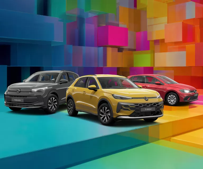 Drei VW-Modelle vor einem bunten, geometrischen Hintergrund aus leuchtenden 3D-Blöcken.