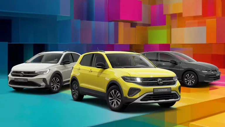 Drei VW-Modelle vor einem bunten, geometrischen Hintergrund aus leuchtenden 3D-Blöcken.