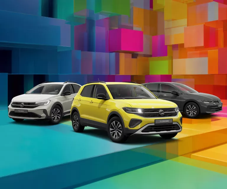 Drei VW-Modelle vor einem bunten, geometrischen Hintergrund aus leuchtenden 3D-Blöcken.