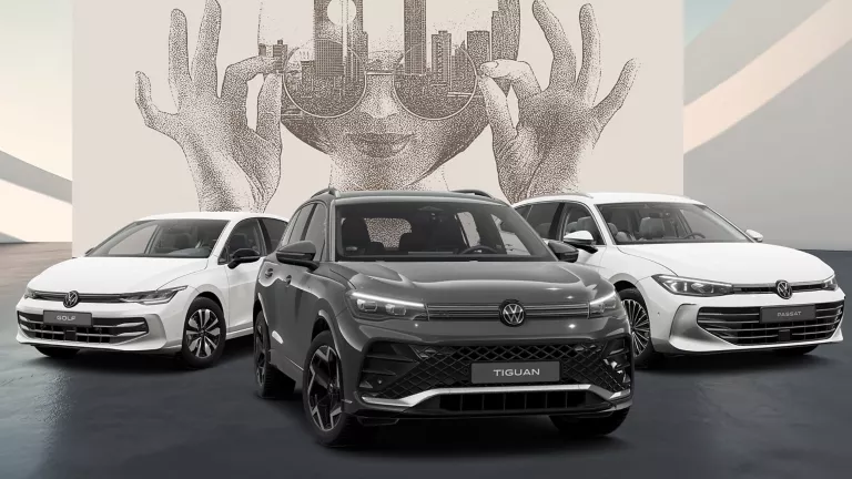 Drei VW Modelle auf schwarzem Boden vor einer Wand mit abstrakter Kunst