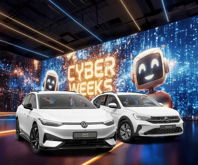 Drei VW-Modelle vor einer großen digitalen Wand mit leuchtendem Schriftzug "CYBER WEEKS" und zwei lächelnden Roboter.