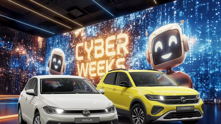 Zwei VW-Modelle vor einer großen digitalen Wand mit leuchtendem Schriftzug "CYBER WEEKS" und zwei lächelnden Roboter.
