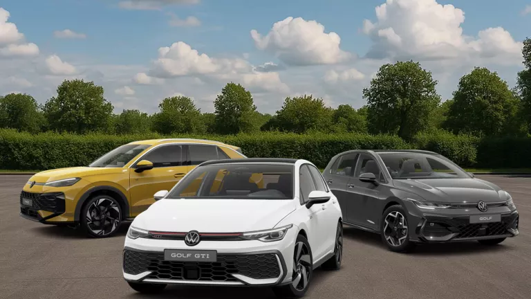 Drei VW Modelle vor Bäumen und Büschen, leicht bewölkter Himmel