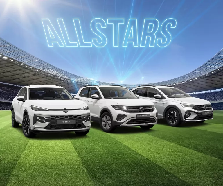 Drei weiße VW SUVs stehen auf einem Fußballfeld im Stadion, darüber leuchtet der Schriftzug „ALLSTARS“.