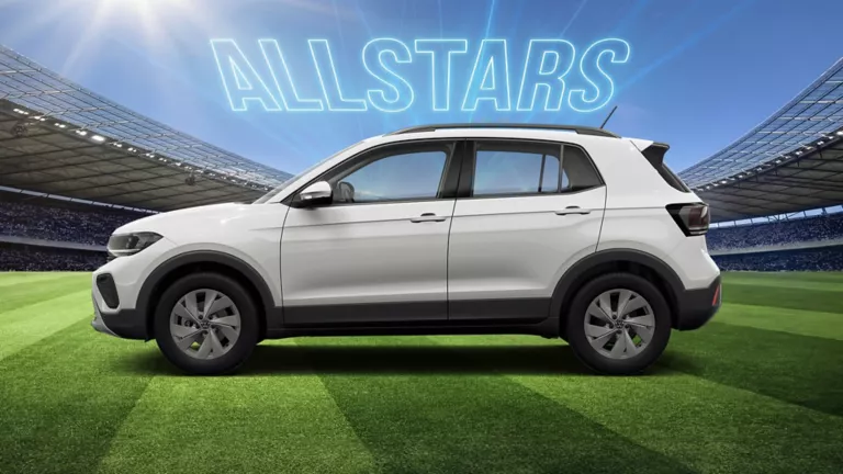 Seitenansicht auf eines weißen VW T-Cross auf einem Fußballfeld im Stadion, darüber leuchtet der Schriftzug „ALLSTARS“.