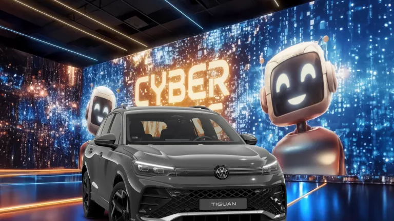 VW Tiguan R-Line in Grau vor einer großen digitalen Wand mit leuchtendem Schriftzug "CYBER WEEKS" und zwei lächelnden Roboter.