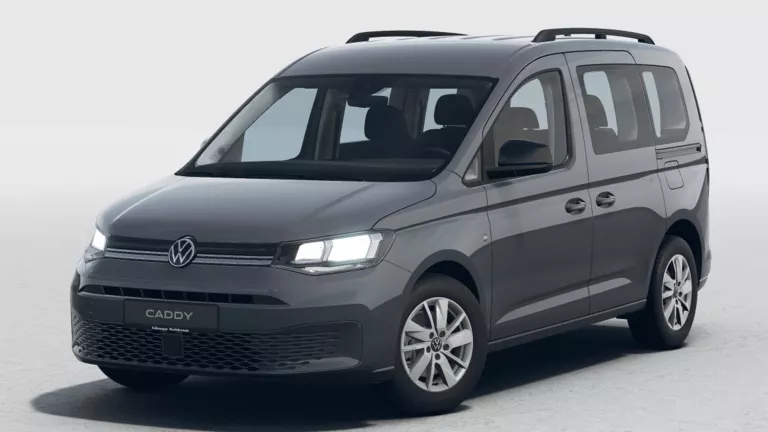 Grauer VW Caddy von schräg vorn vor hellem Hintergrund.