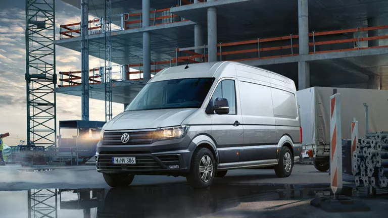 Ein VW Crafter Kastenwagen fährt von einer Baustelle weg.