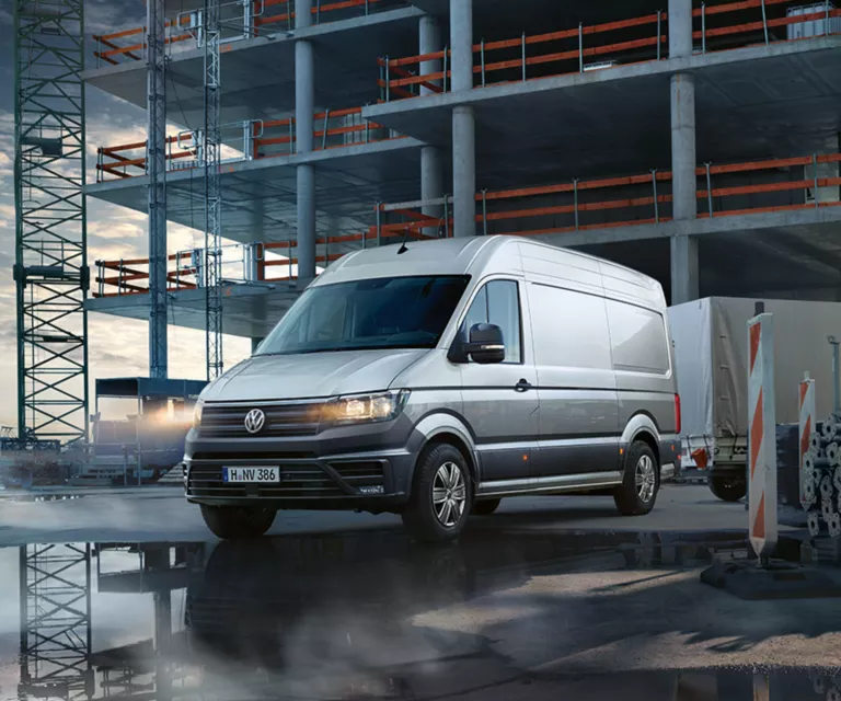 Ein VW Crafter Kastenwagen fährt von einer Baustelle weg.