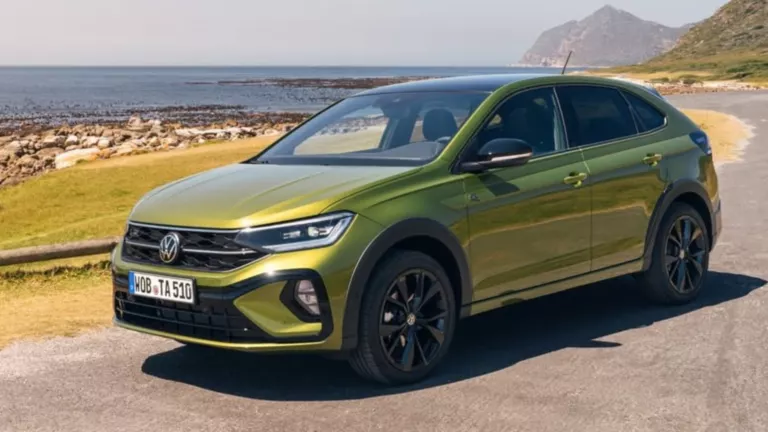 Volkswagen Taigo verde circulando por carretera con vistas al mar